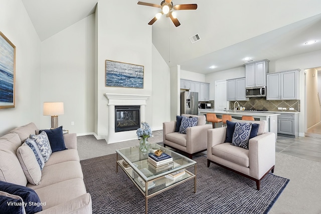 carpeted living room featuring high vaulted ceiling and ceiling fan