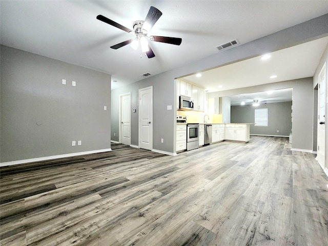 unfurnished living room featuring ceiling fan and light hardwood / wood-style floors