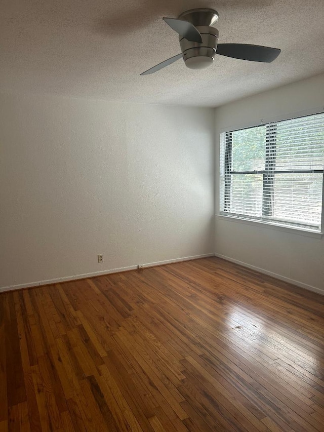 unfurnished room featuring ceiling fan, dark wood-type flooring, and a textured ceiling