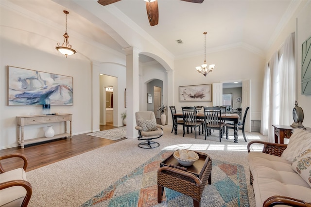 living room featuring light carpet, crown molding, ceiling fan with notable chandelier, and high vaulted ceiling