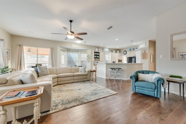 living room with dark wood-type flooring and ceiling fan