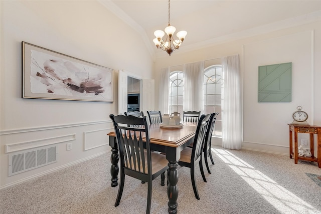 dining room featuring ornamental molding, vaulted ceiling, light colored carpet, and a chandelier