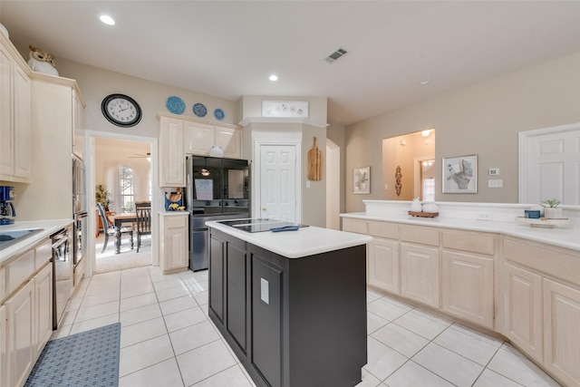 kitchen featuring stainless steel appliances, a center island, sink, and light tile patterned floors