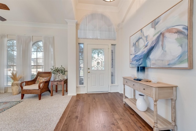 entrance foyer with ornamental molding and light hardwood / wood-style floors