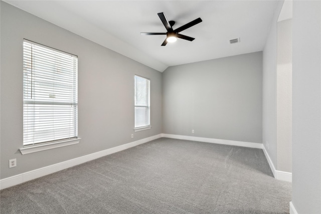 carpeted empty room featuring vaulted ceiling and ceiling fan