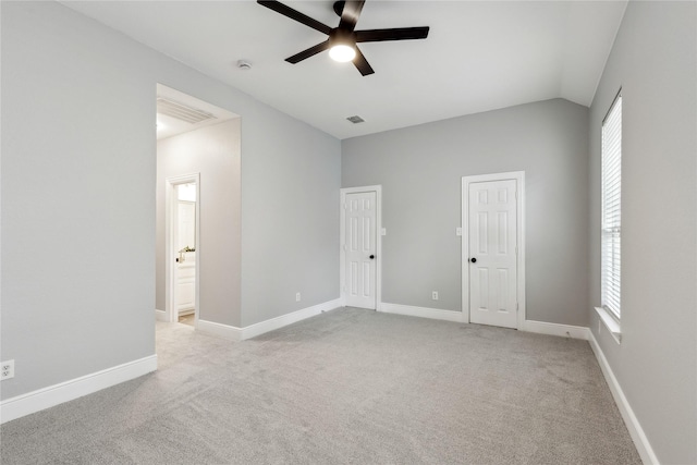 carpeted empty room featuring vaulted ceiling and ceiling fan