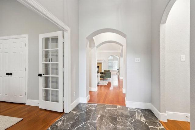 corridor featuring ornamental molding and dark wood-type flooring