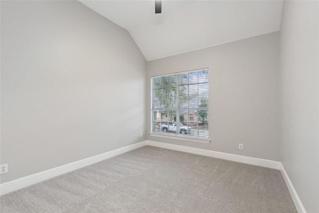 carpeted spare room featuring ceiling fan and vaulted ceiling