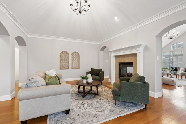 living room featuring wood-type flooring, crown molding, and a chandelier