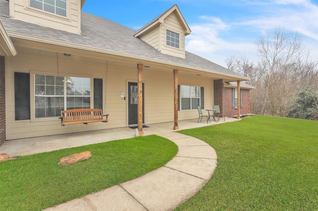 rear view of property featuring a patio and a yard