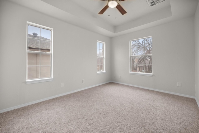 spare room with carpet floors, a raised ceiling, and ceiling fan