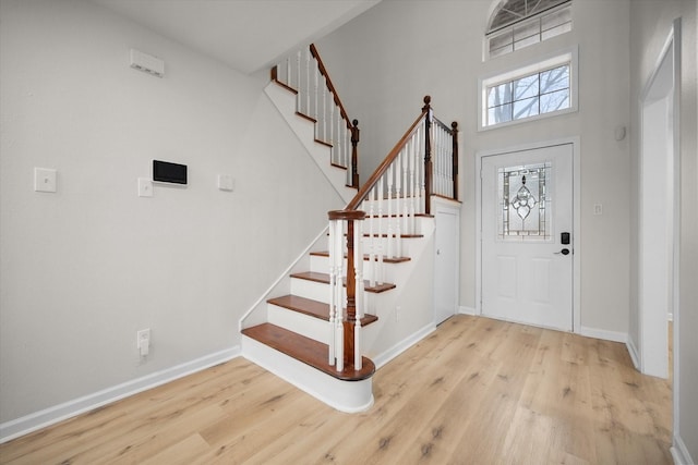 foyer entrance with a high ceiling and light hardwood / wood-style flooring