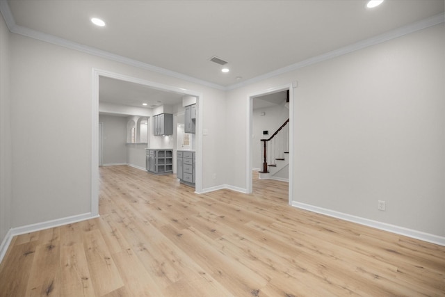 unfurnished living room with crown molding and light hardwood / wood-style floors