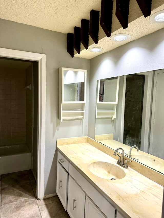 bathroom with vanity, tile patterned floors, a textured ceiling, and a tub to relax in