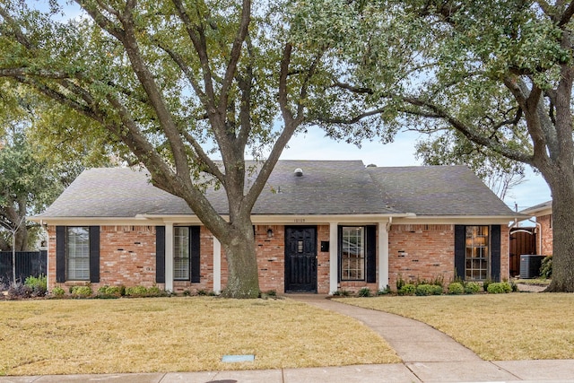 ranch-style home featuring cooling unit and a front lawn