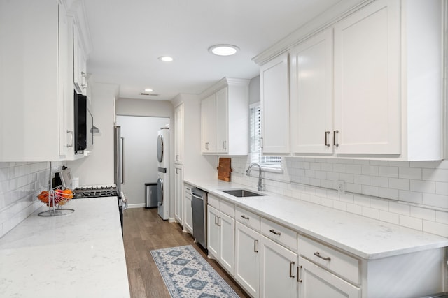 kitchen with dark hardwood / wood-style floors, sink, white cabinets, stainless steel appliances, and light stone countertops