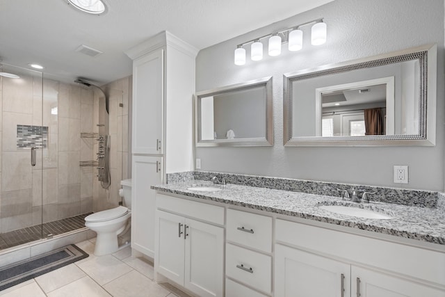 bathroom with vanity, tile patterned flooring, a shower with shower door, and toilet