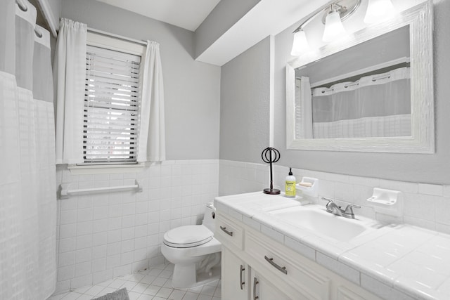 bathroom with vanity, tile walls, tile patterned floors, and toilet