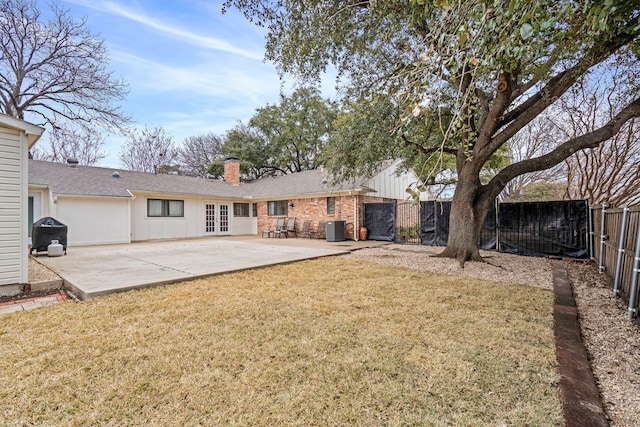 back of property featuring cooling unit, a yard, a patio, and french doors