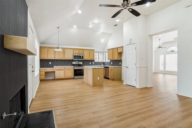 kitchen with tasteful backsplash, hanging light fixtures, a center island, light hardwood / wood-style floors, and stainless steel appliances