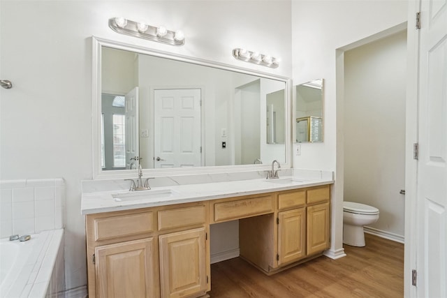 2324 Spring Mills Rd, Mesquite, TX 75181 - full bath with double vanity, wood finished floors, toilet, a bath, and a sink