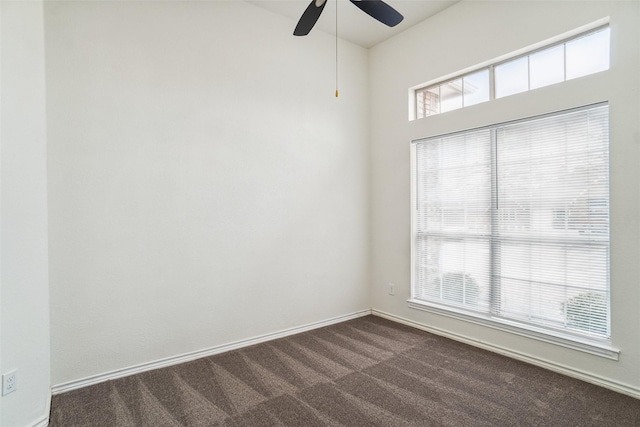 empty room with dark colored carpet and ceiling fan