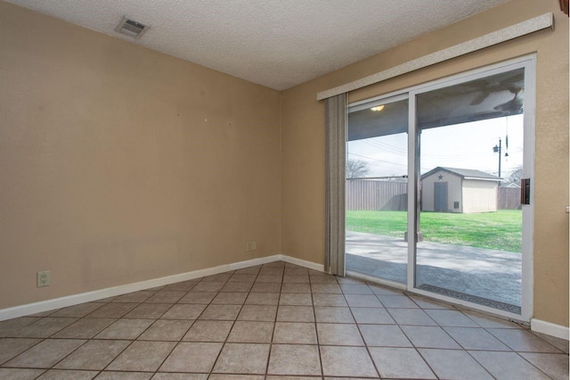 empty room with light tile patterned floors and a textured ceiling