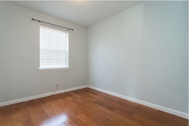 unfurnished room with wood-type flooring