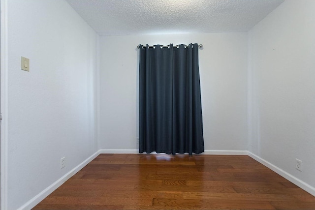 unfurnished room featuring wood-type flooring and a textured ceiling