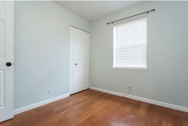 unfurnished bedroom with wood-type flooring and a closet