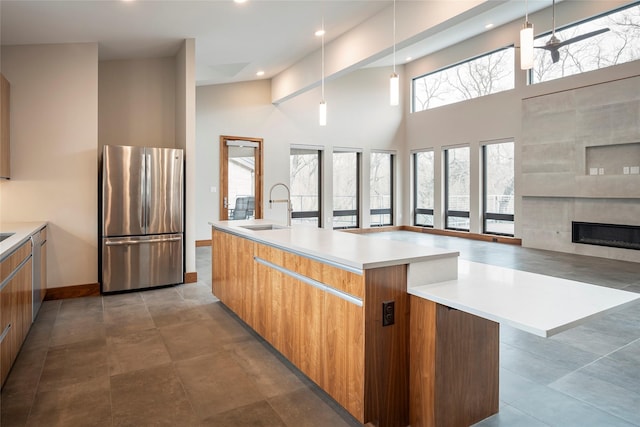 kitchen featuring stainless steel appliances, an island with sink, sink, and pendant lighting