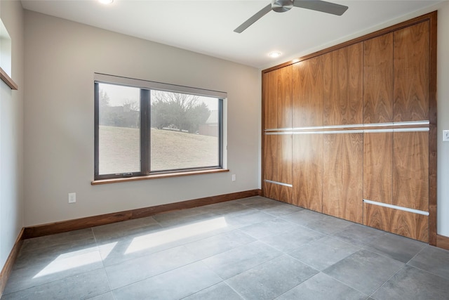 tiled spare room with ceiling fan