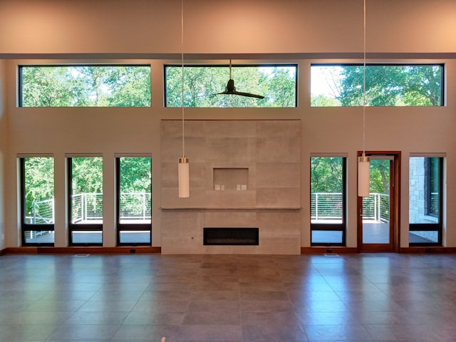 1621 Caddys Cir, Garland, TX 75043 - unfurnished living room featuring a towering ceiling, tile patterned floors, healthy amount of natural light, and a fireplace