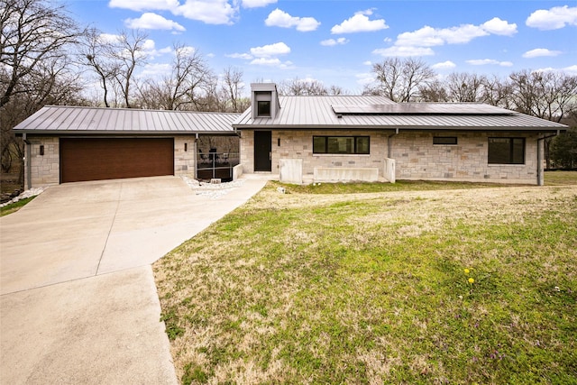 view of front facade featuring a garage, solar panels, and a front lawn