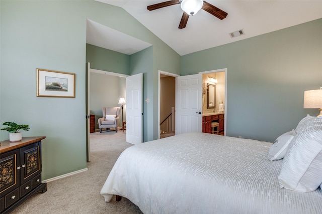 bedroom featuring ensuite bathroom, lofted ceiling, light colored carpet, and ceiling fan