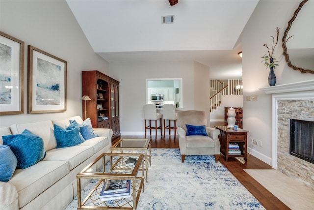 living room featuring hardwood / wood-style flooring, a fireplace, and vaulted ceiling