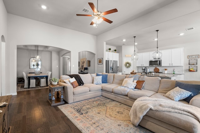 living room with ceiling fan, sink, and dark hardwood / wood-style flooring