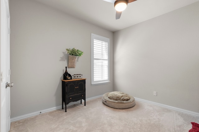 living area featuring light colored carpet and ceiling fan