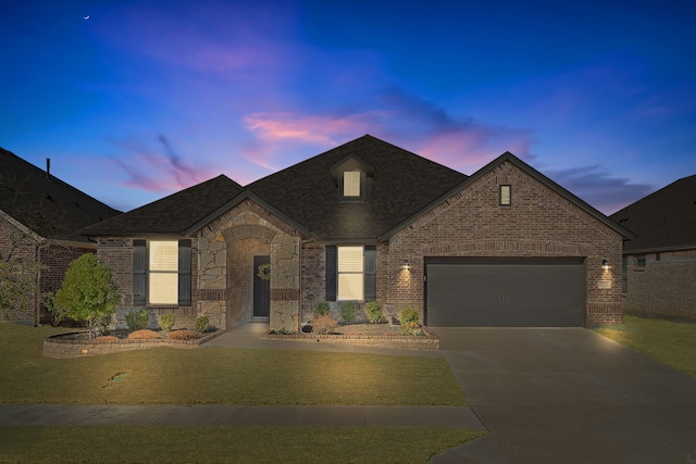 french country inspired facade featuring a yard and a garage