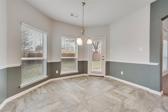 unfurnished dining area featuring a notable chandelier