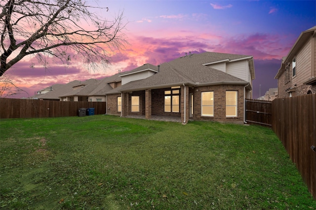 back house at dusk with a yard