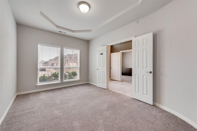 200 Ravenel St, Glenn Heights, TX 75154 - unfurnished bedroom featuring light carpet, a raised ceiling, and baseboards