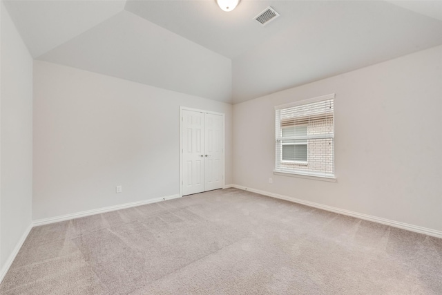 unfurnished room with vaulted ceiling and light colored carpet