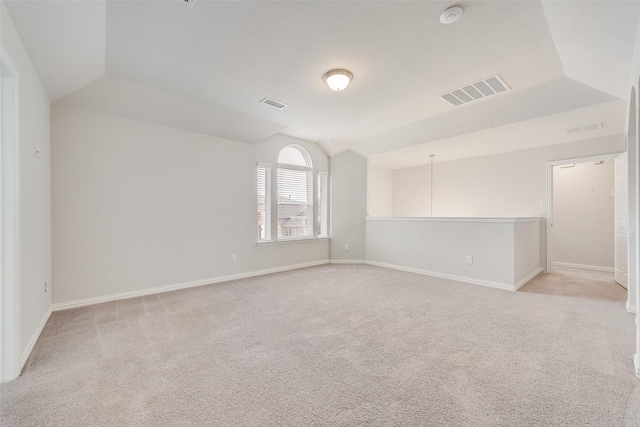 unfurnished room with vaulted ceiling and light carpet