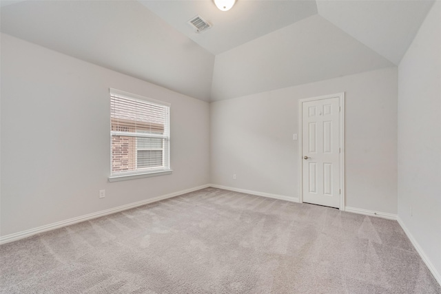 carpeted spare room featuring lofted ceiling