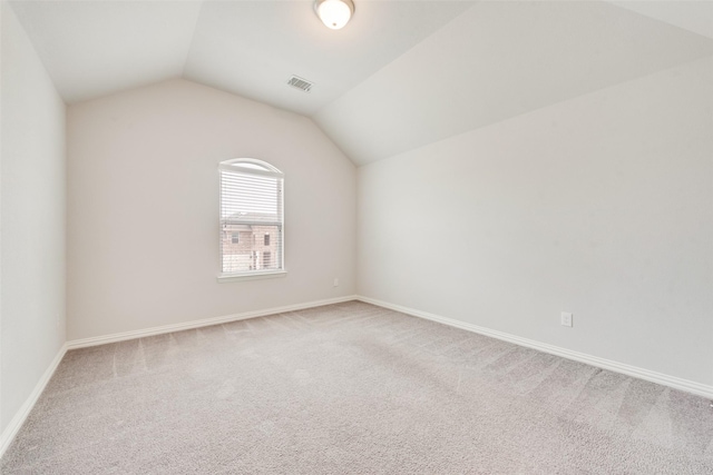 unfurnished room featuring lofted ceiling and carpet floors