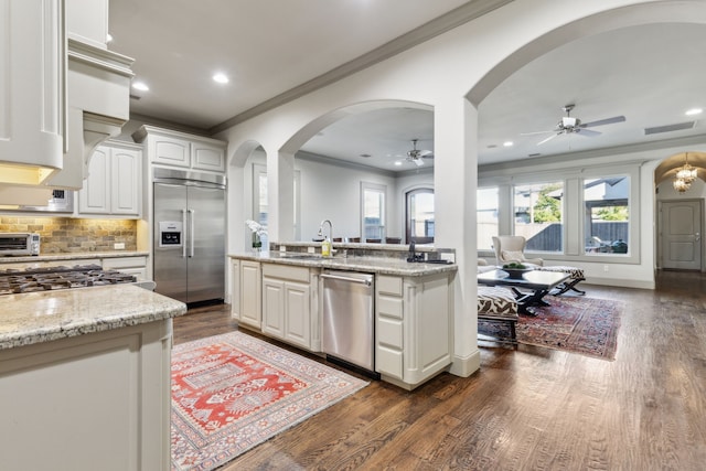 kitchen with white cabinetry, sink, light stone counters, and stainless steel appliances