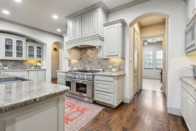 kitchen featuring sink, white cabinetry, light stone counters, ornamental molding, and stainless steel appliances