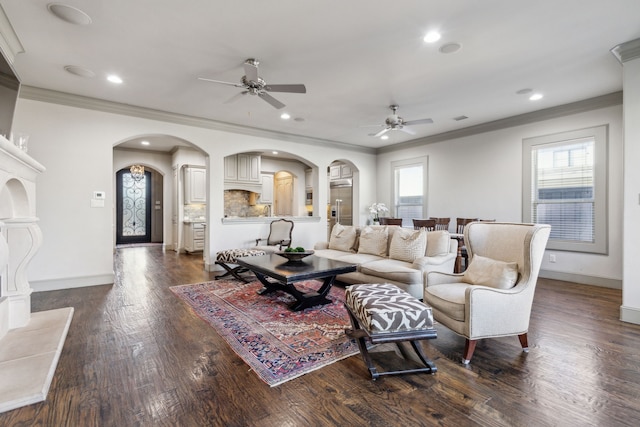 living room with dark wood-type flooring, ceiling fan, ornamental molding, and a wealth of natural light