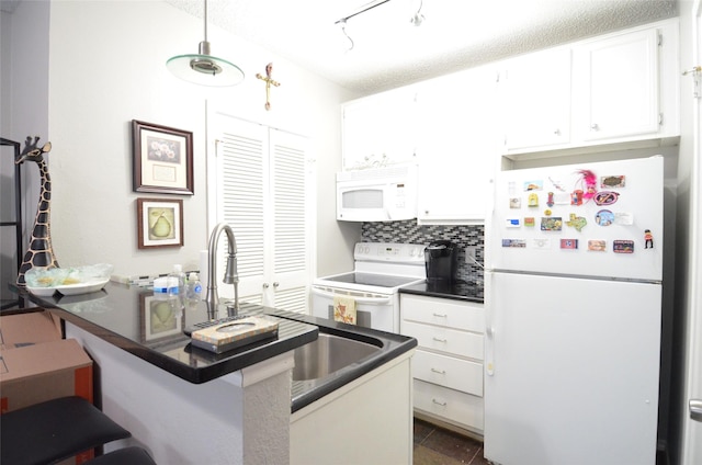 kitchen with white cabinetry, a kitchen breakfast bar, kitchen peninsula, white appliances, and backsplash